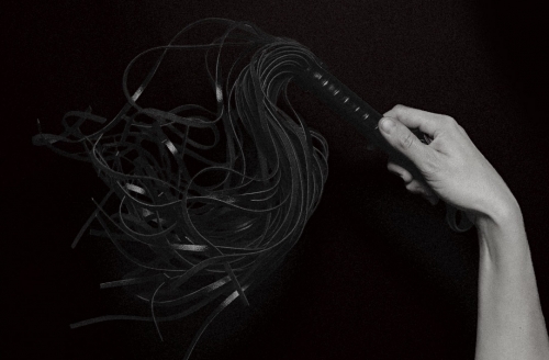 Peitsche in der Hand